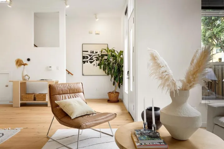 Light wood-finish flooring complements white walls throughout this living space