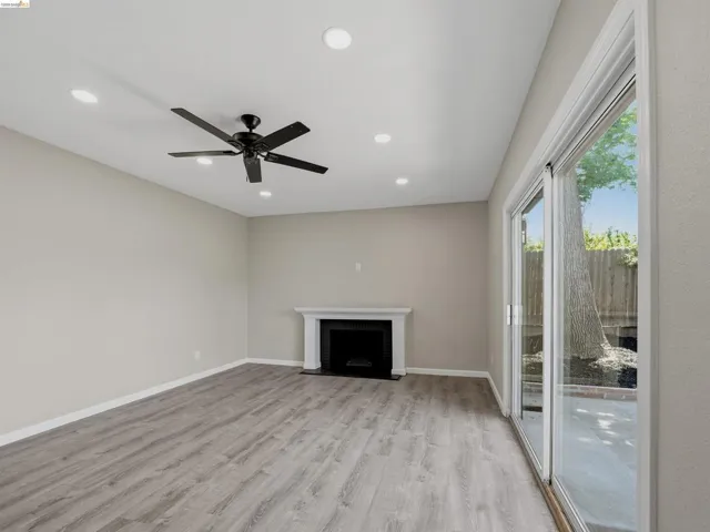 Spacious room featuring wood-finish flooring, recessed lighting, and a contemporary ceiling fan