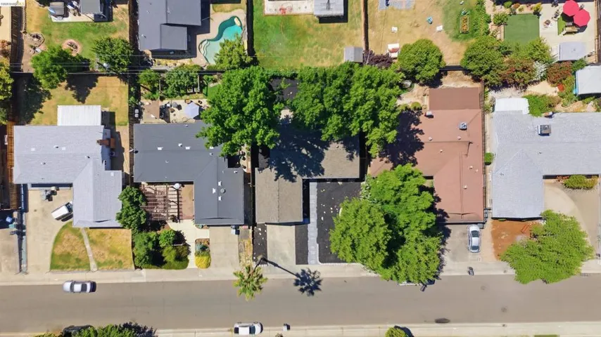 Residential property featuring a dark gray pitched roof and an expansive driveway