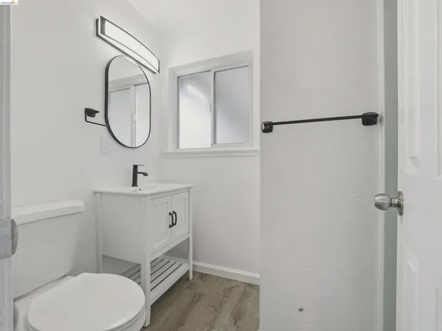 Bathroom featuring a white vanity with black hardware, a rectangular sink, and a matte black single-lever faucet