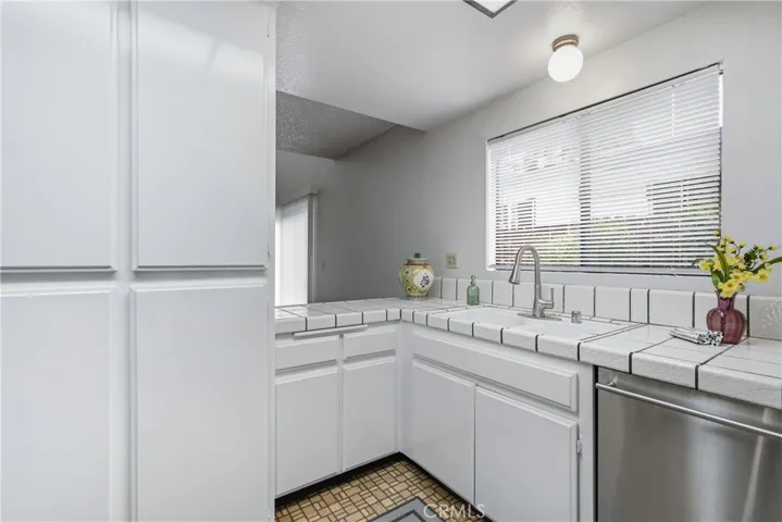 Kitchen with Tile Countertops and Dishwasher