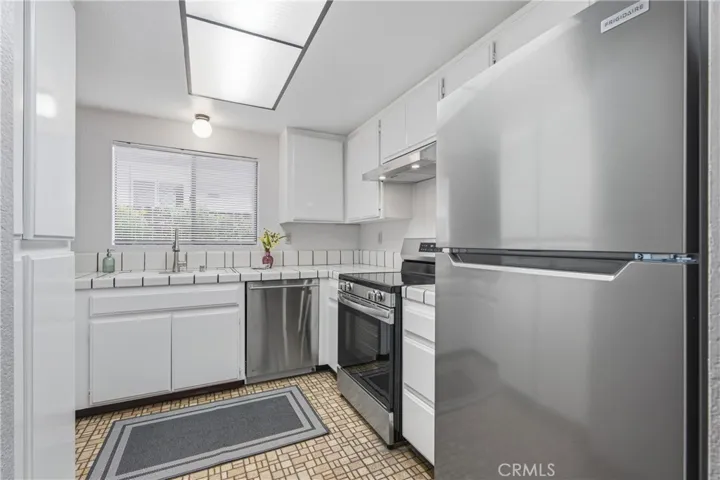 Kitchen with Tile Countertops, Dishwasher and New Stove and Refrigerator