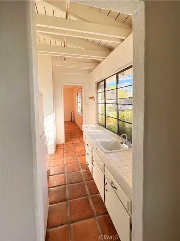 Galley style kitchen, with new stove and refrigerator.
