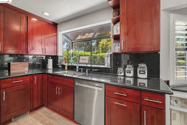 Kitchen with rich wood cabinetry and black countertops