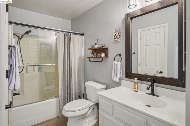 Bathroom featuring a white vanity with a white countertop, a rectangular undermount sink, and a black faucet