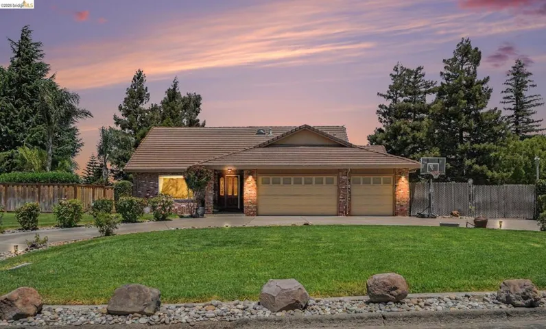 Brick exterior with a tiled roof and an attached two-car garage