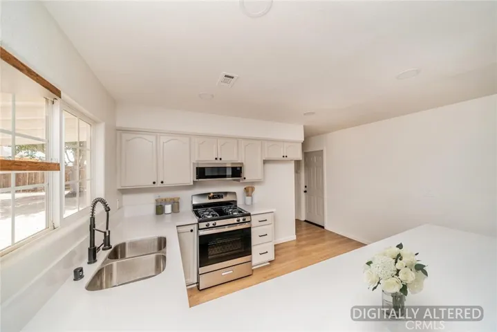 Remodeled Kitchen (Disclaimer: Some images have been digitally enhanced with virtual staging to illustrate potential room layouts and furnishings. Actual property condition and features may vary. Buyer to verify all information independently).