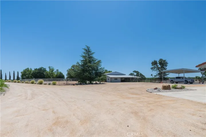 A view to the entry on the left, the pole barn and carport on the right.