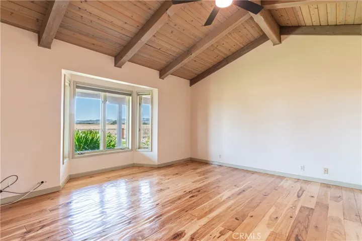 Vaulted ceiling and bayed window accent this primary bedroom