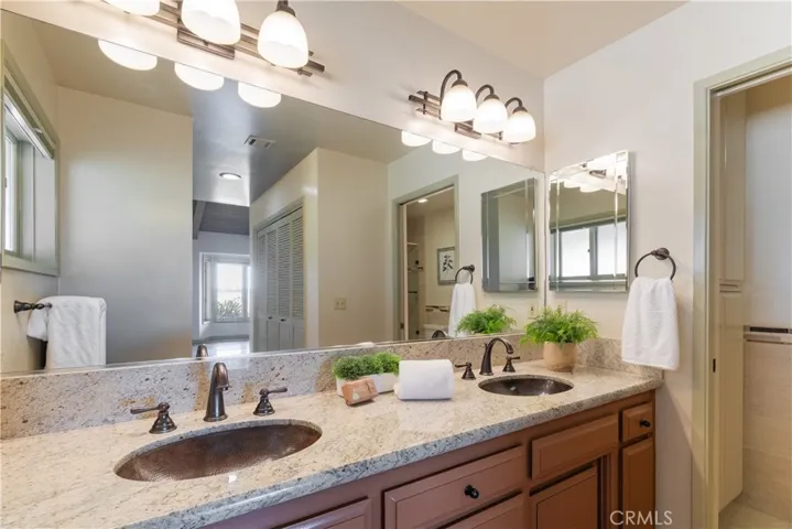 Double hammered sinks and granite counters are a part of this beautiful primary bathroom