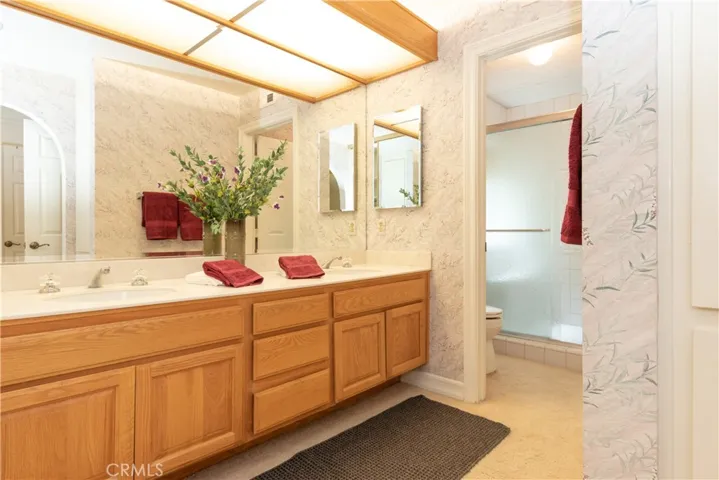 Dual vanities in the primary bathroom, with an extra large glass enclosed shower.