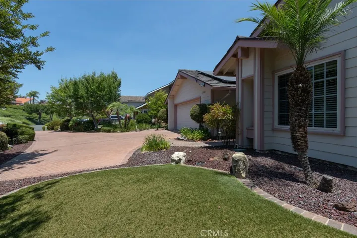 Turf front yard with garden beds surrounding it.