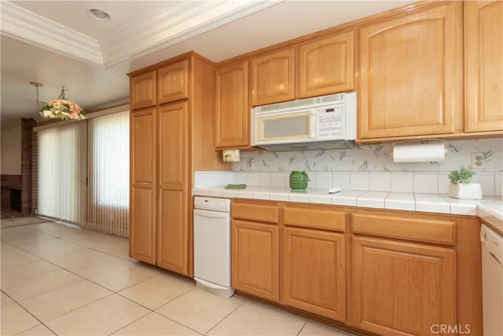 Tile floor, tray ceiling with recessed light, electric cooktop with microwave above...