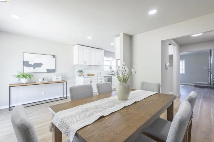 Open-concept dining area featuring light-tone wood-finish flooring, recessed lighting, and a neutral color palette