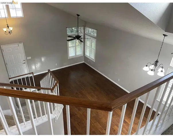 Entry foyer showcasing wood-finish flooring, a two-story ceiling, and a traditional chandelier