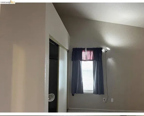 Sliding closet doors and vaulted ceiling, complemented by window blinds