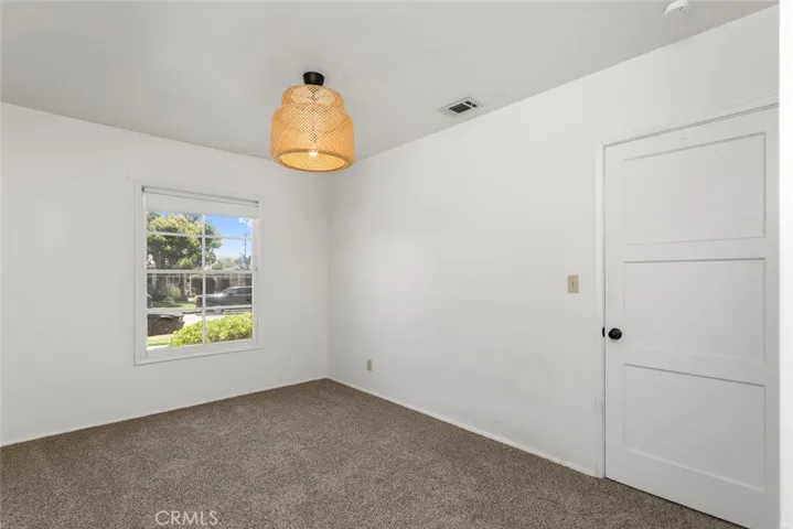 Front bedroom with vintage light fixture, neighborhood views, and new carpet.
