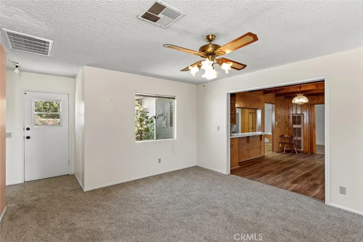 Family room with vintage ceiling fan and new carpet.