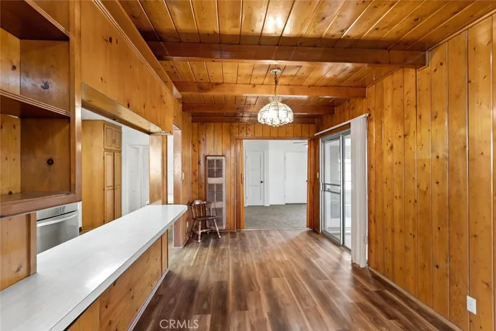 Wood paneled dining room with breakfast bar and vintage Tiffany-style light fixture.