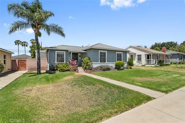 697 N 8th Avenue with walkway, lawn, and steps leading to the front door.