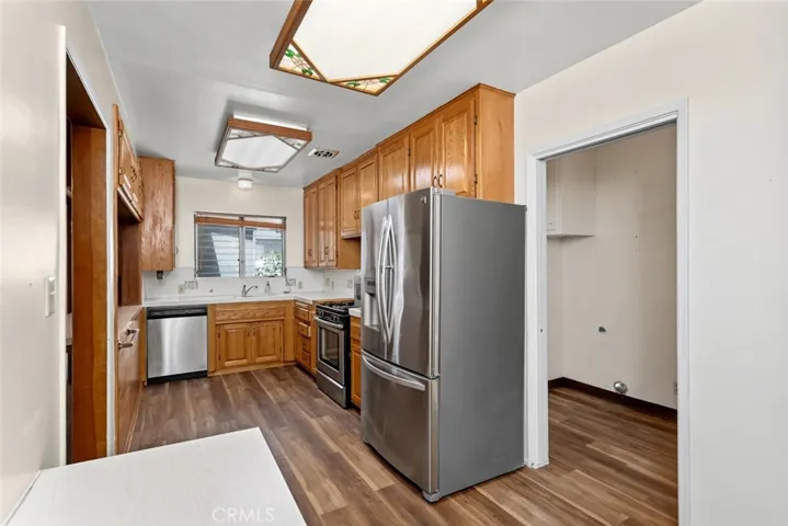 Kitchen with new wood-vinyl flooring, and stainless appliances.