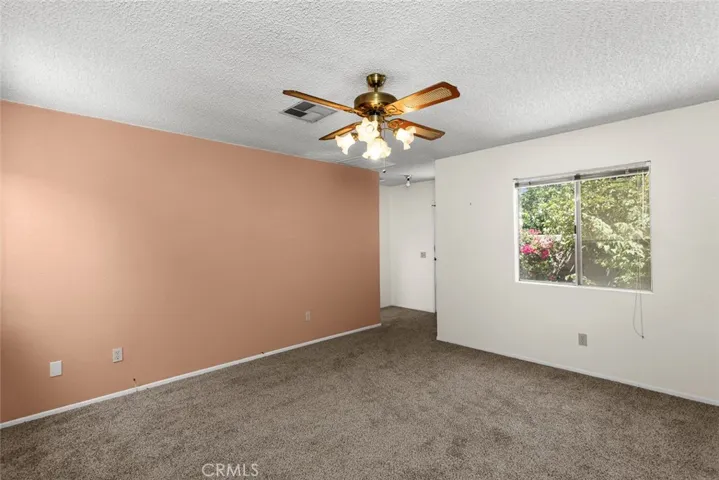 Family room with new carpet and vintage ceiling fan.