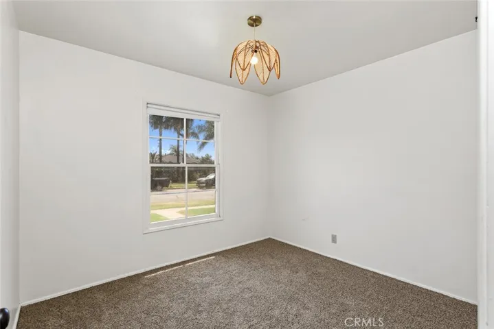 Front bedroom with vintage light fixture and new carpet.