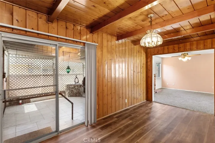 Wood-paneled dining room with sliding door access to the covered patio.