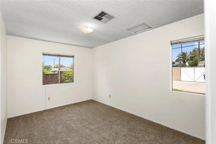 Back bedroom with new carpet and view of the backyard.