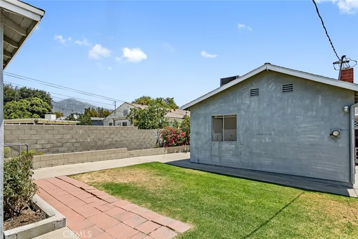 Backyard with lawn and pavers.