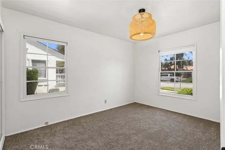 Front bedroom with vintage light fixture, neighborhood views, and new carpet.