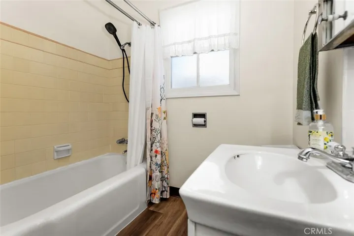 Full bathroom with bathtub and new wood-vinyl flooring.