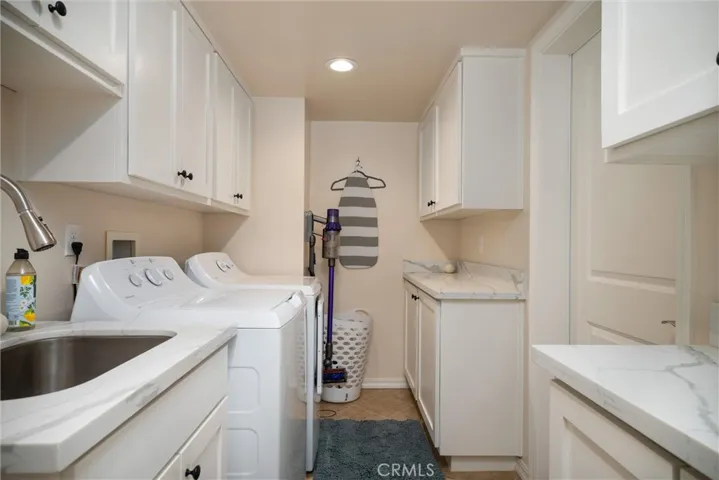 Main level laundry room with sink and door to spacious garage