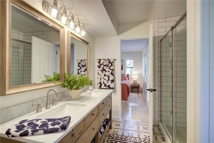 Walk-in shower with designer tile accents and glass enclosure.