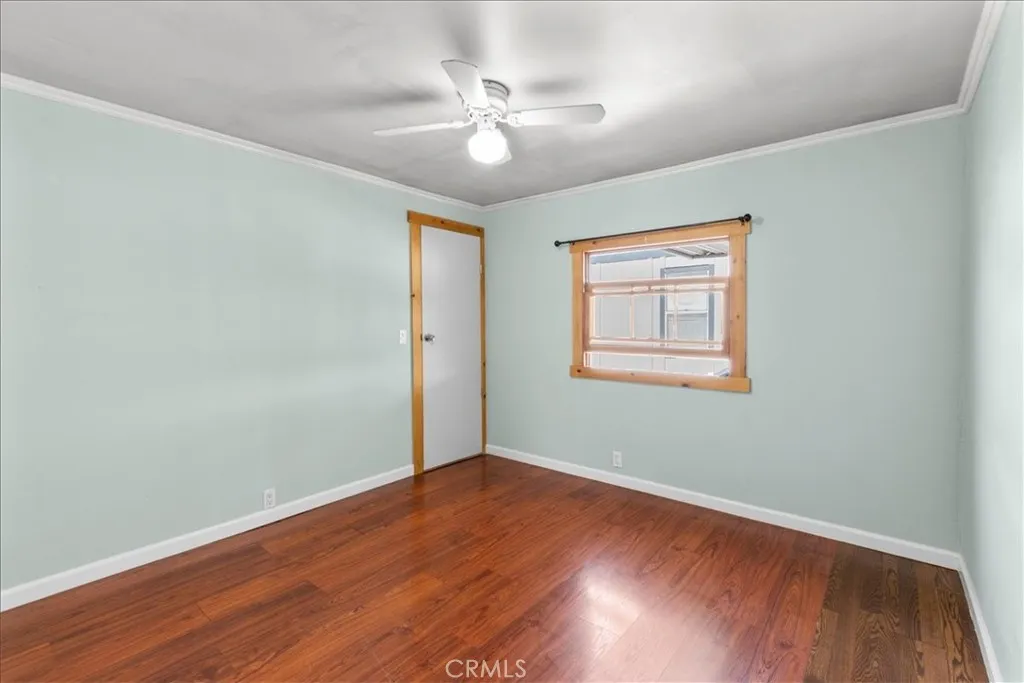 Guest bedroom with wood flooring