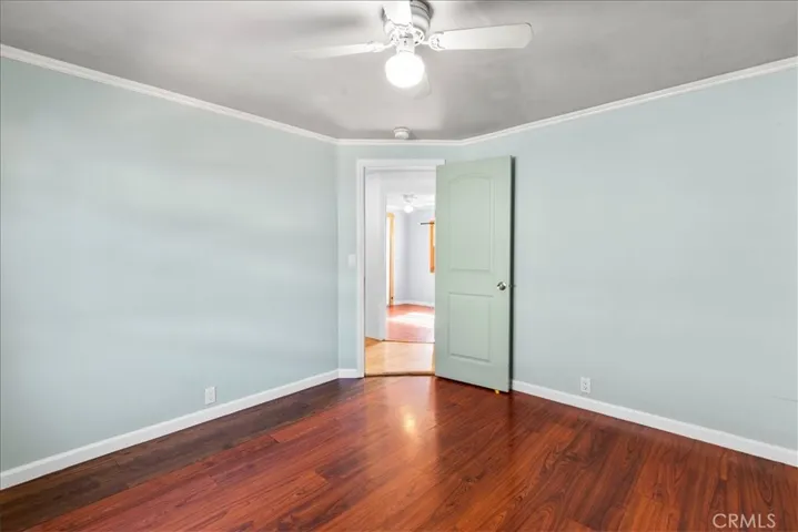 Guest bedroom with wood flooring
