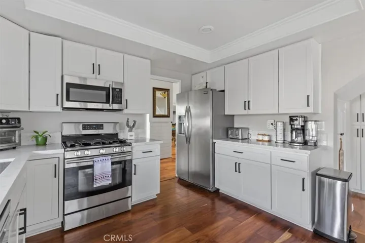 kitchen featuring white shaker cabinetry, quartz countertops, stainless steel appliances
