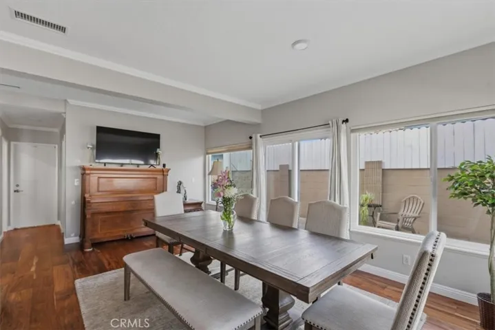 Spacious dining area with large windows that bring in abundant natural light while overlooking the private patio.