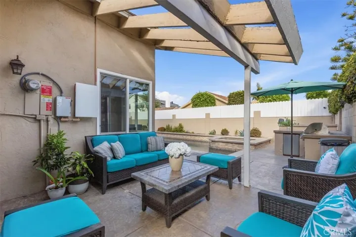Covered patio with comfortable outdoor seating, built-in BBQ, and direct access to the pool and spa, creating the perfect space for year-round entertaining and outdoor dining.