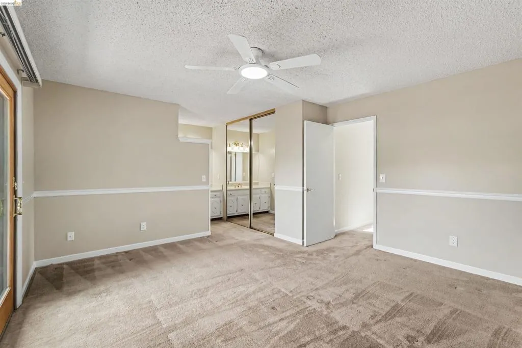 Carpeted interior with neutral wall paint and white chair rail molding