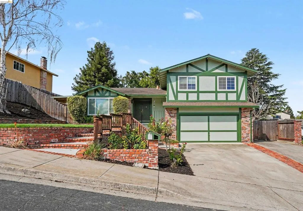 Tudor-style exterior with green trim and white siding
