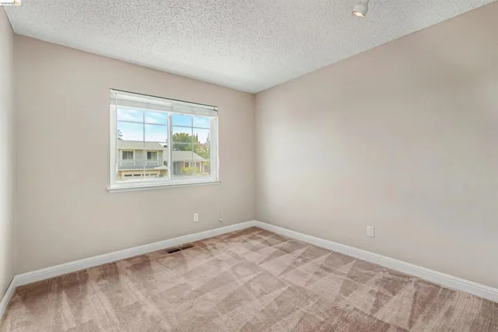 Neutral-toned walls complement patterned carpet flooring