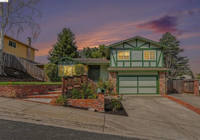 Two-story residence featuring a distinctive Tudor-inspired exterior with board-and-batten siding in sage green and cream tones, complemented by decorative timber framing