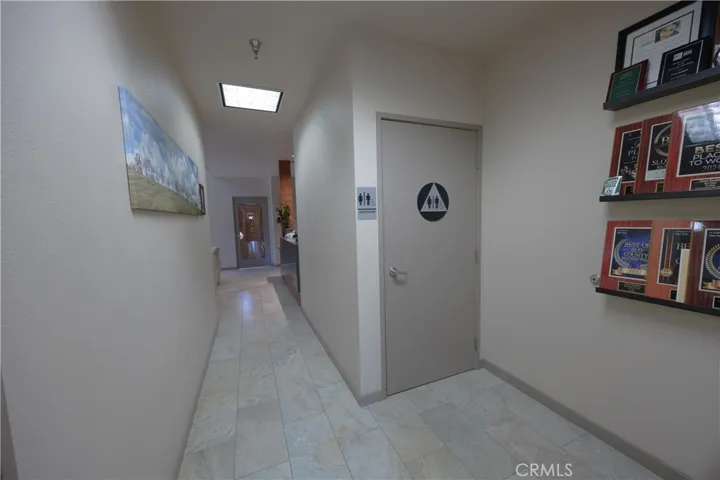 View looking back toward the lobby and conference room, featuring a standard restroom and a mailroom located across the hall.