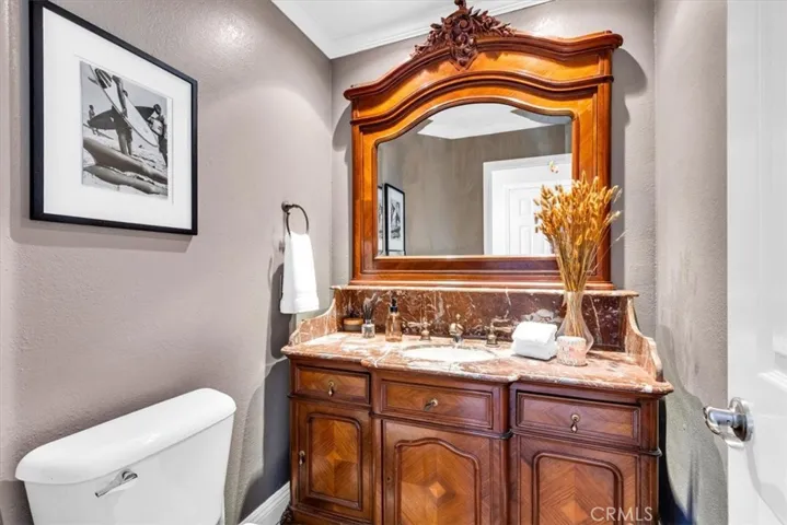 Even the powder bath got the memo: wood vanity, overmantle mirror, quietly elegant.
