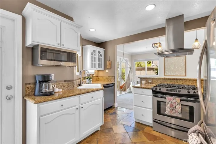 Granite, gas range, wine fridge, and a hood vent that means business. This kitchen cooks.