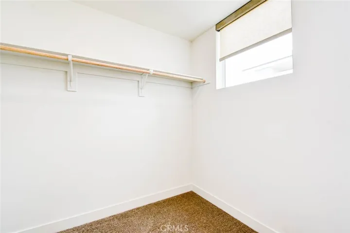 The primary bedroom walk-in closet with window.