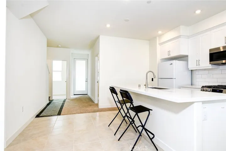 The original living room is converted into anther room. The glass room on the right side at the end of this photo leads to the balcony. The door on the left side leads to the original office on this floor.