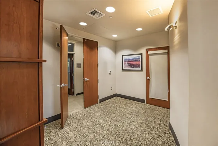 Entrance to Ste A conference rooms on either side as well as hallway leading to kitchen and restrooms. Ste B is on the other side of closed door.