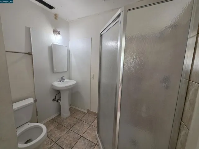 The primary bathroom has a sink with a vanity mirror, a toilet, and a shower.
